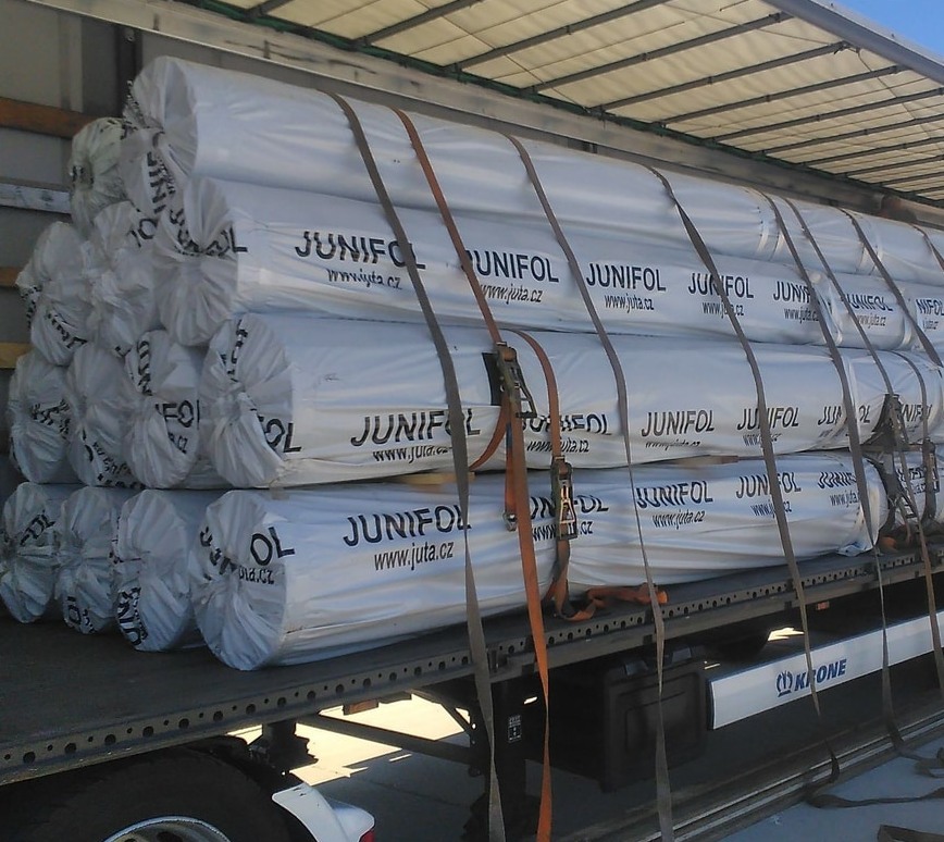 Rouleaux de géomembrane PEHD JUNIFOL chargés sur camion pour livraison sur chantier — géomembrane PEHD 2 mm